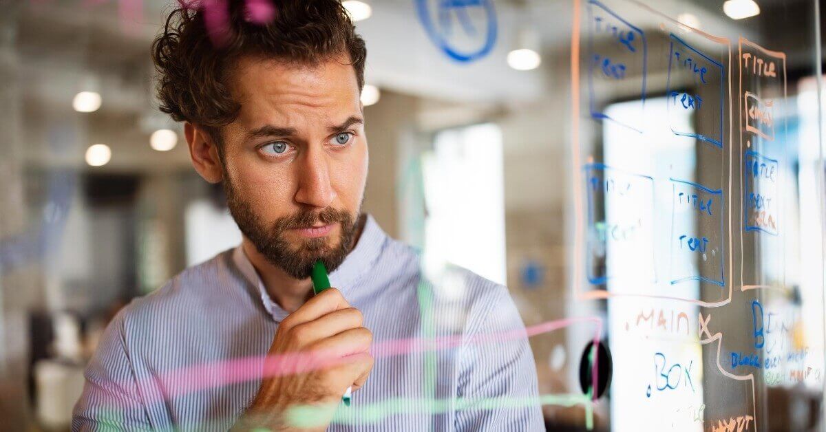 Software developer, writing with marker on glass surface